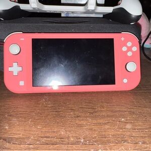 Nintendo Switch Lite in coral with case, handles and charger
